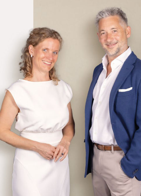 IASIS Elements-Kleid an einer lächelnden Frau neben einem lächelnden Mann im blauen Blazer und einer hellen Hose.